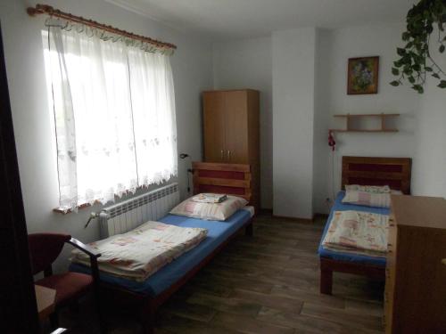 a room with two beds and a window at Gościniec Suwalska in Gołdap