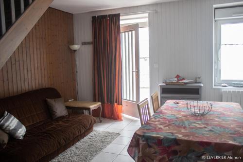 a living room with a couch and a table at Logis des chouans in Les Landes-Génusson