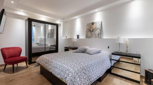 een slaapkamer met een bed en een rode stoel bij 3-bedroom apartment Quai des Grands Augustins in Parijs