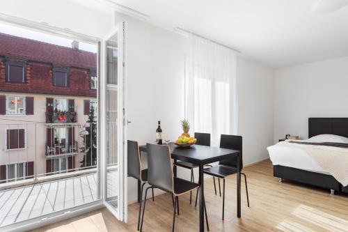 a dining room with a table and chairs and a bedroom at Swiss Star Wiedikon - Self Check-In in Zurich