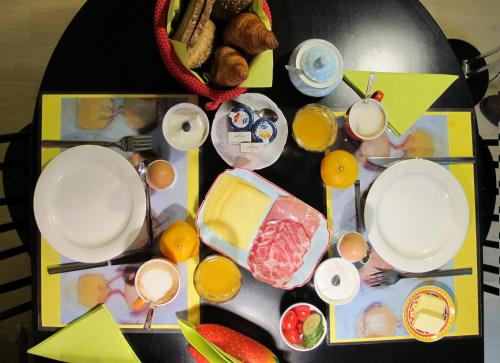 une table recouverte d'assiettes, de tasses et de nourriture dans l'établissement De Slaapmus, à Boven-Leeuwen