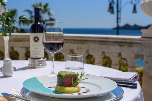 a plate of food on a table with a glass of wine at Imperiale Palace Hotel in Santa Margherita Ligure