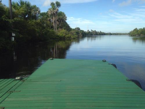 a boat dock on a river with trees and water at Chalé em Barreirinhas - Porto dos Lençóis in Barreirinhas
