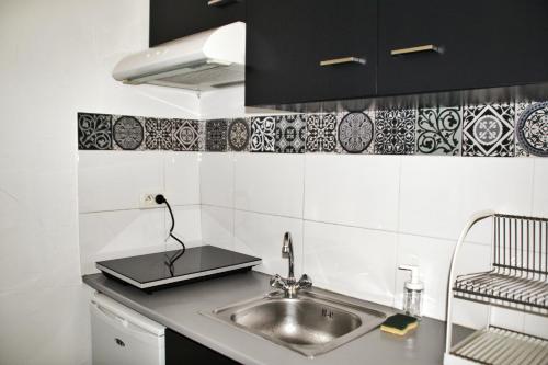 モンペリエにあるLa Fontaine - Studio Ecussonの- シンク付きのキッチン(白黒のタイル張り)
