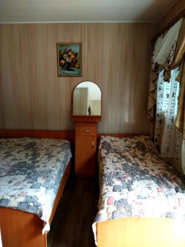 a bedroom with two beds and a mirror at Mini Hotel Уютный дворик in Odesa