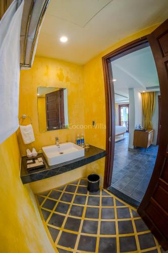a bathroom with a sink and a mirror at Cocoon Villa in Hoi An