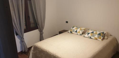um quarto com uma cama com duas almofadas em FONTANA SERI em Ulassai