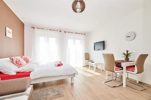 een slaapkamer met een bed en een tafel en stoelen bij Studio apartman Lena in Umag