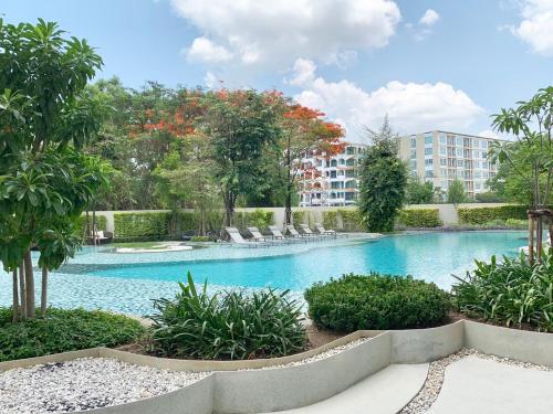 Una gran piscina con un edificio al fondo. en Summer Huahin Condo612,Near beach&Cicada,Beautiful swimming pool, en Hua Hin