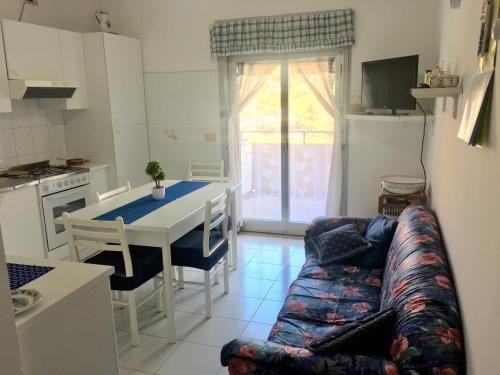 cocina y sala de estar con sofá y mesa en Casa Vacanza “La Mantinera”, en Falcone