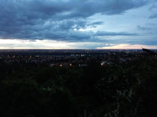 a plane flying over a city under a cloudy sky at Just nature in Novi Sad