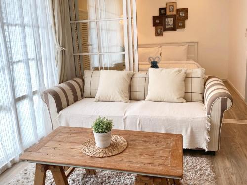 Una sala de estar con un sofá y una mesa de café. en Summer Huahin Condo612,Near beach&Cicada,Beautiful swimming pool, en Hua Hin