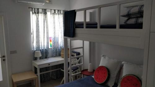 a small room with a bunk bed and a desk at Little Blue House in Marsalforn