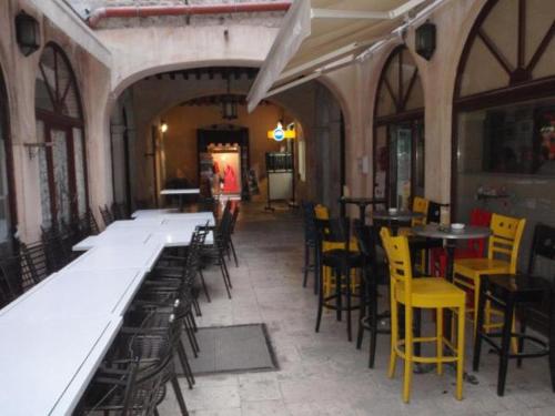 an empty restaurant with tables and yellow chairs at Opium Old City Apartment in Split