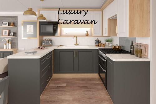 a kitchen with a sink and a stove top oven at Inverbeg Holiday Park in Luss