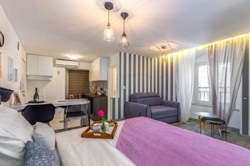a bedroom with a purple bed and a kitchen at Forever apartment & rooms in Rijeka