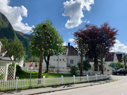 a white fence in front of a white house at Høyanger 3 roms leilighet in Høyanger