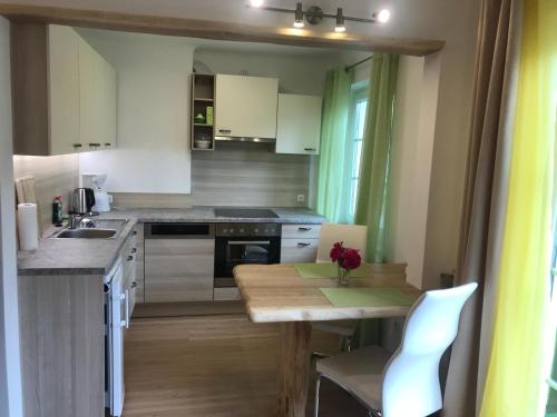 a kitchen with white cabinets and a table and a sink at Wohnung am See in Steinbach am Attersee