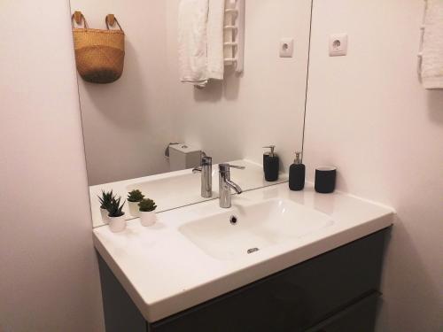 La salle de bains est pourvue d'un lavabo blanc et d'un miroir. dans l'établissement Pedras D'el Rei Waterfront Loft, à Tavira
