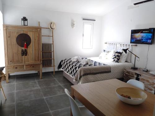 a living room with a bed and a table with a dining room at Pedras D'el Rei Waterfront Loft in Tavira