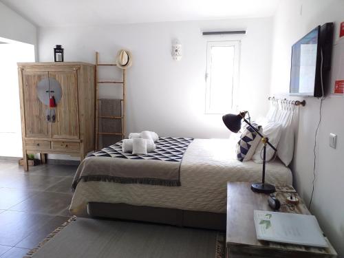 a bedroom with a bed and a dresser in it at Pedras D'el Rei Waterfront Loft in Tavira