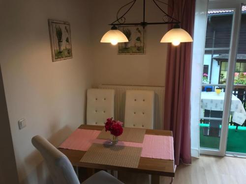 a dining room table with a vase of flowers on it at Wohnung am See in Steinbach am Attersee