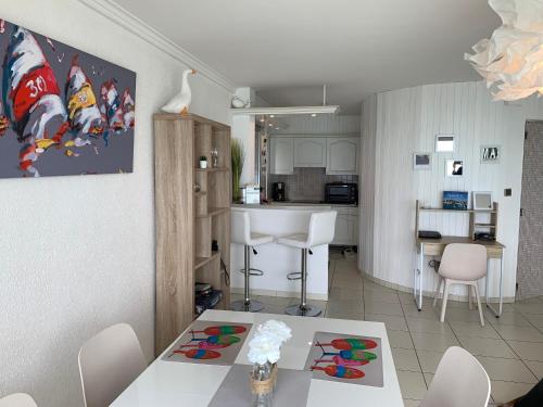 a living room and kitchen with a table and chairs at Les pieds dans l'eau accès direct à la plage ! in Granville