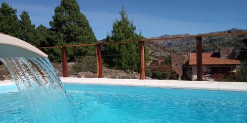 a swimming pool with a water fountain at Balcones de La Cumbrecita in La Cumbrecita