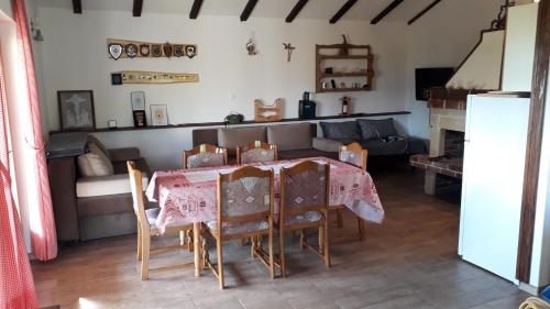a dining room with a table and chairs and a couch at Weekend House Petar in Lusnić