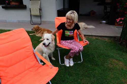 a woman sitting in an orange chair with a dog at B&B Scotty & Co. in Susa