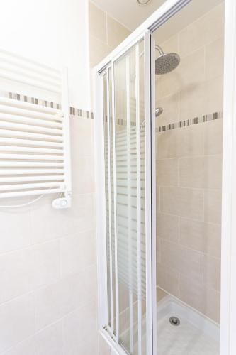 une douche avec une porte vitrée dans une salle de bain dans l'établissement Angels Inn, à Coutevroult