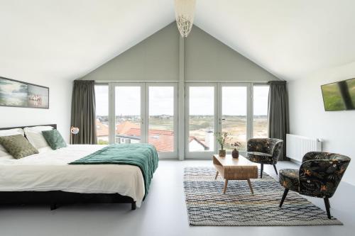 a bedroom with a bed and a large window at Paulus Loot Zandvoort in Zandvoort