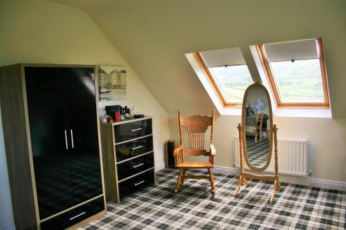 a room with a mirror and a chair and a dresser at Wild Atlantic View Inishowen in Greencastle