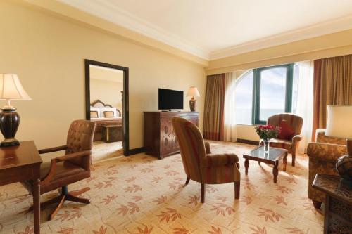 a living room with a couch and a table and a mirror at Djibouti Palace Kempinski in Djibouti
