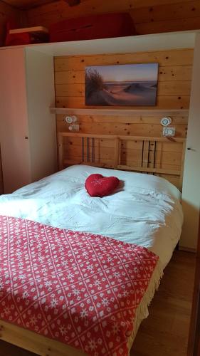 a bed with a red pillow on top of it at Chalet Lake Lugano, Vienna 18 in Porlezza