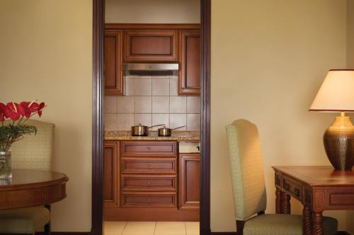 a kitchen with wooden cabinets and a table and a desk at Djibouti Palace Kempinski in Djibouti