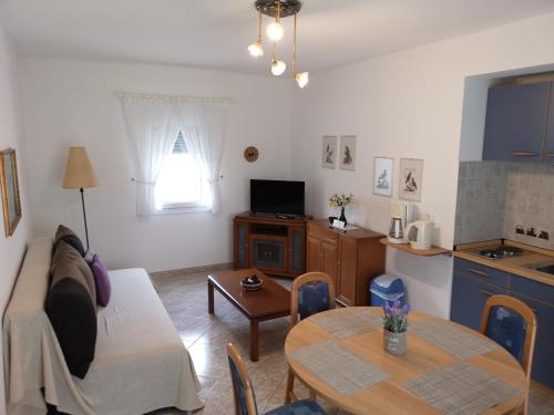 Susanna Apartments في كيراموتي: غرفة معيشة مع أريكة وطاولة
