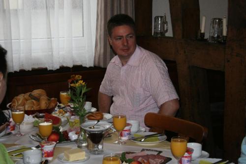 a man sitting at a table with food on it at Gasthof Postkutsche in Motten