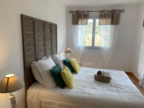 a bedroom with a large white bed with colorful pillows at Villa Pampasgiolu in Tizzano