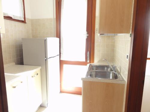 a small kitchen with a sink and a refrigerator at Villa Agavi 2 in Bibione