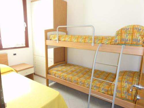 a room with two bunk beds and a table at Villa Agavi 2 in Bibione
