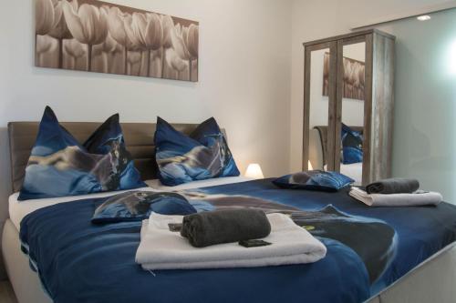 a bedroom with two beds with blue sheets and a mirror at Apartments Gerda in Vřesina