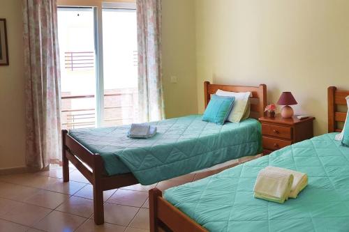 une chambre avec deux lits et une fenêtre dans l'établissement Best Located Apt - Fabulous Pool !, à Cabanas de Tavira
