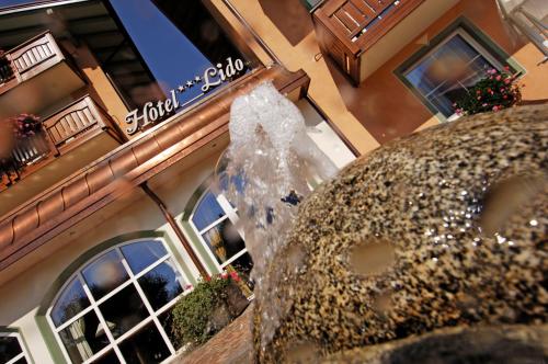a water fountain in front of a building at Hotel Lido - slow & natural living in Molveno
