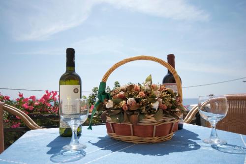 a basket of flowers and a bottle of wine on a table at Sarikampos Beach in Myrtos