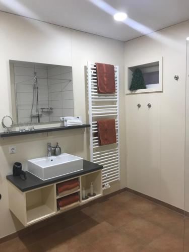 a bathroom with a sink and a mirror at Ferienwohnung Zum alten Rathaus in Schleiden