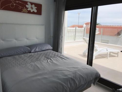 a bedroom with a bed and a view of a balcony at Martin Stone Mil Palmeras Beach in La Horadada