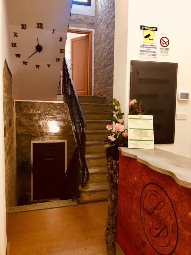 a room with a staircase with a clock on the wall at La Vecchia Posta B&B in Calangianus