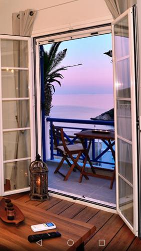 a room with a view of the ocean through a sliding glass door at Deck1Syros Premium Apartments in Vári