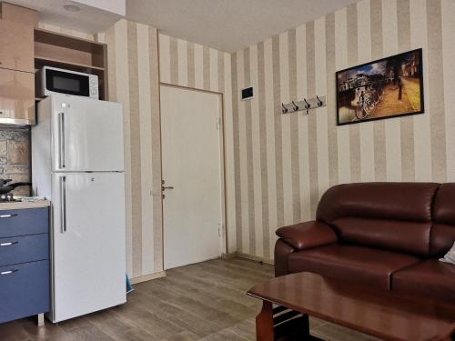 a living room with a white refrigerator and a couch at Vacation home in Gonio in Gonio